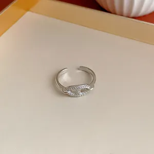 Vista ravvicinata di un anello regolabile in argento con pavé di zirconi geometrico.