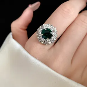 Detailed macro view of a vintage palace style ring featuring a green stone and halo diamonds.