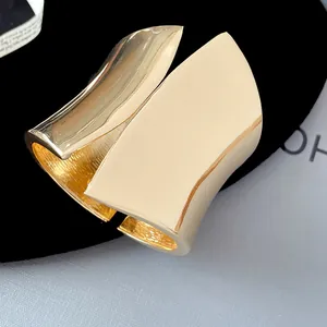 Detailed macro shot of the wide asymmetrical golden open cuff bracelet with polished finish