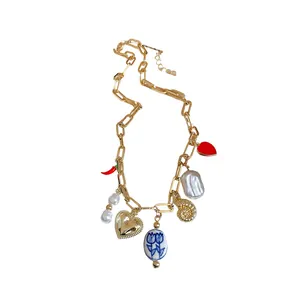 Gold chunky chain necklace with mixed charms like heart, pearl, and chili pepper