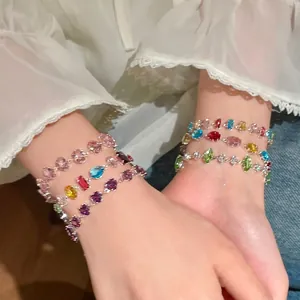 Detailed view of stackable dopamine colorful cubic zirconia bracelets on wrist