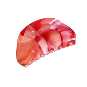 Elegant red and white marble patterned acrylic hair claw clip for a stylish back bun look.