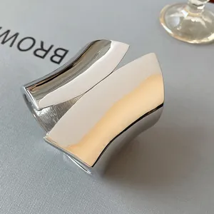 Macro view of minimalist asymmetrical wide open cuff bracelet with high-polish silver finish