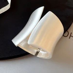 Close-up of asymmetrical wide silver cuff bracelet with matte brushed finish
