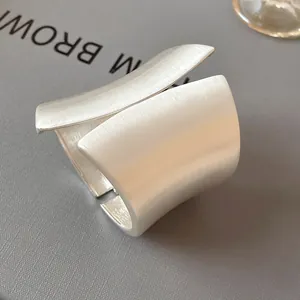Close-up of a wide asymmetrical silver cuff bracelet with a brushed matte finish detail