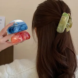 Detail showing the elegant marbled texture of acrylic hair claw clips in various colors