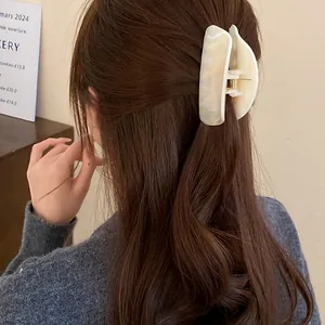 Close-up of marbled acrylic hair claw clip worn on wavy brown hair