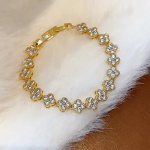 Detail view of gold-plated bracelet with sparkling zircon-encrusted flower links.