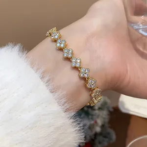 Close-up of gold-plated bracelet with zircon-inlaid flower links on model wrist