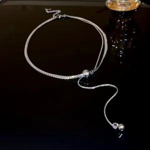 Detailed view of an elegant silver-toned adjustable Y-necklace with shiny metallic beads