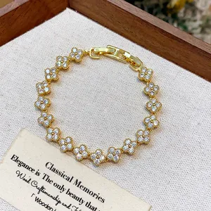Detailed macro view of a gold-plated flower bracelet with sparkling zircons in a wooden box