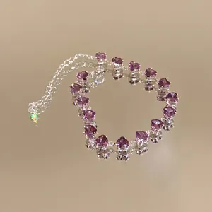 Close-up of purple heart-shaped zircon bracelet on a reflective mirror surface