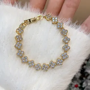Close-up of gold-plated bracelet with pavé cubic zirconia flower clover motifs