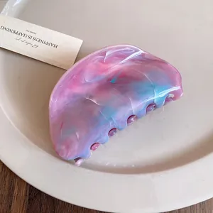Macro detail of acrylic marble hair claw clip featuring pink and blue watercolor textures