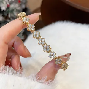 Detailed macro view of elegant gold-plated flower bracelet with sparkling micro-pave zircons