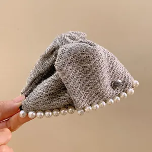 Gray tweed triangular hair claw clip with pearl trim and metal badge detail