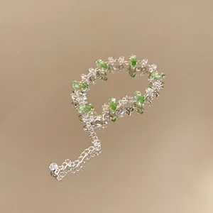 Close-up of a sparkling silver bracelet with green and white marquise-cut zircons