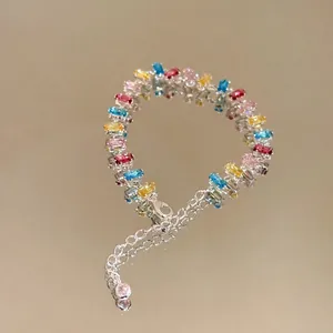 Detailed view of colorful rectangular zircon bracelet on reflective surface.