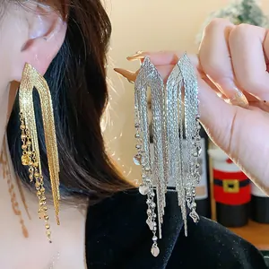 Detailed view of gold and silver long tassel earrings with shimmering metal beads