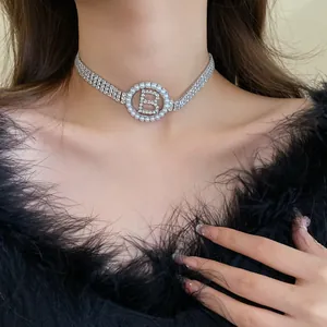 Close-up of a sparkling zircon choker necklace with a pearl-framed B-letter pendant