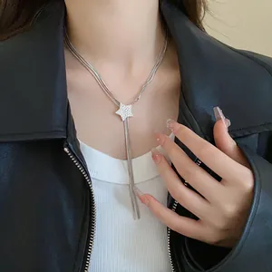 Close-up of sparkling star pendant necklace with long silver tassels on a model