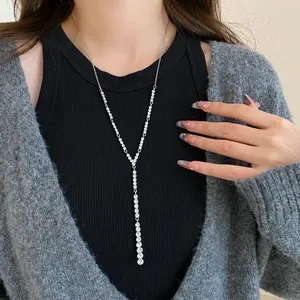 Detailed view of a silver-toned long Y-shaped necklace featuring sparkling zircon stones.