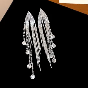 Close-up of elegant 18k gold plated silver needle long tassel earrings with disc charms