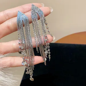Detail view of silver tassel earrings with delicate beaded strands and metallic discs.