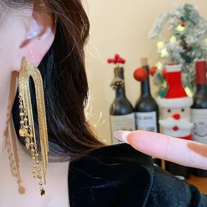 Close-up of elegant 18k gold-plated long tassel earrings worn by a model in a festive setting