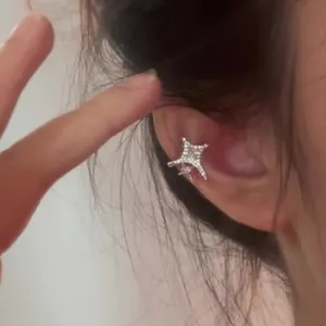 Shimmering zircon star ear cuff for non-pierced ears worn on the ear cartilage.