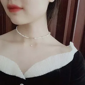 Elegant detail of a French baroque pearl choker necklace worn by a female model.