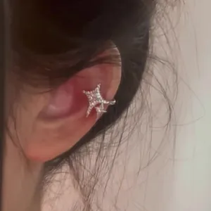 Close-up of elegant star zircon ear cuff worn on the ear bone, Korean fashion style