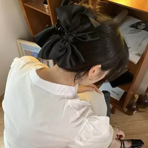 Vista dettagliata di un'elegante molletta per capelli con fiocco in raso nero