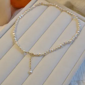 Macro detail view of a French baroque pearl necklace with golden adjustable chain clasp