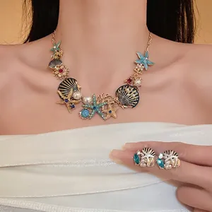 Elegantes Schmuckset mit Seesternen, Muscheln und Perlen, getragen von einem Modell in weichem Licht