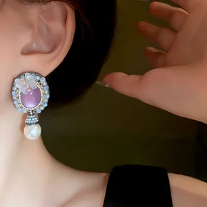 Vintage palace style earrings featuring a purple oval stone, butterfly accent, and pearl drop