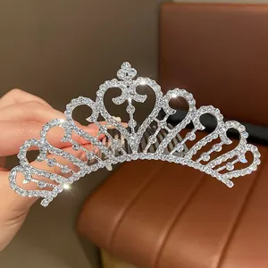 Primo piano di una tiara d'argento scintillante con motivi a cuore e strass