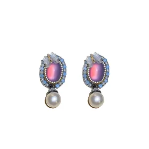 Vintage oval earrings with pink stone, butterfly accent, and elegant pearl drops.
