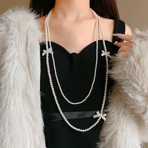 Vue détaillée d'un collier long à double rangée de perles de culture avec nœuds sur modèle.