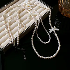 Collier élégant à plusieurs rangs de perles avec nœuds blancs, style français.