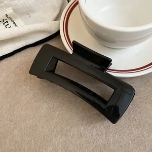 Detailed macro view of minimalist black rectangular hair claw clip for women's hairstyle