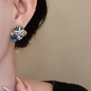 Detailansicht eines eleganten Ohrrings mit Seestern, Perlen und blauem Edelstein