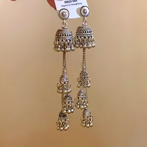 Dettaglio degli orecchini lunghi a nappa in stile regale vintage con campanelli