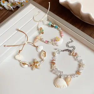 Close-up detail of handmade ocean-themed bracelets featuring sea shells and natural stones