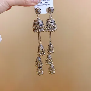 Vista dettagliata di orecchini a nappa vintage con intricate trame metalliche d'argento.