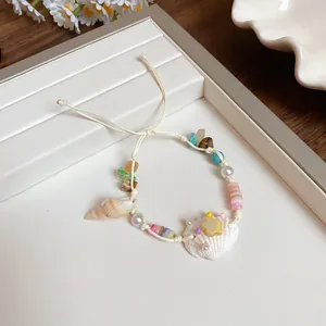 Detailed close-up of a handmade shell bracelet with natural stones and starfish charm