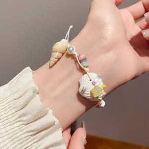 Close-up of handmade sea shell and pearl bracelet on wrist, summer vacation style