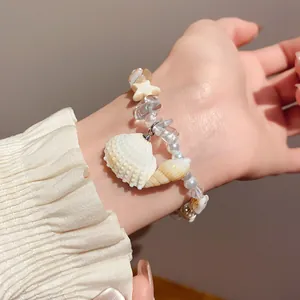 Close-up detail of beach-inspired bracelet with natural stones and ceramic shells