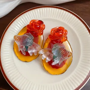 Detail view of resin koi fish and flower earrings with traditional Chinese aesthetics