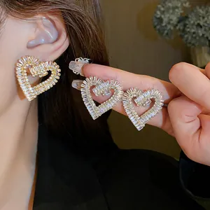 Primo piano di orecchini a cuore scintillanti con pietre di zircone a baguette.